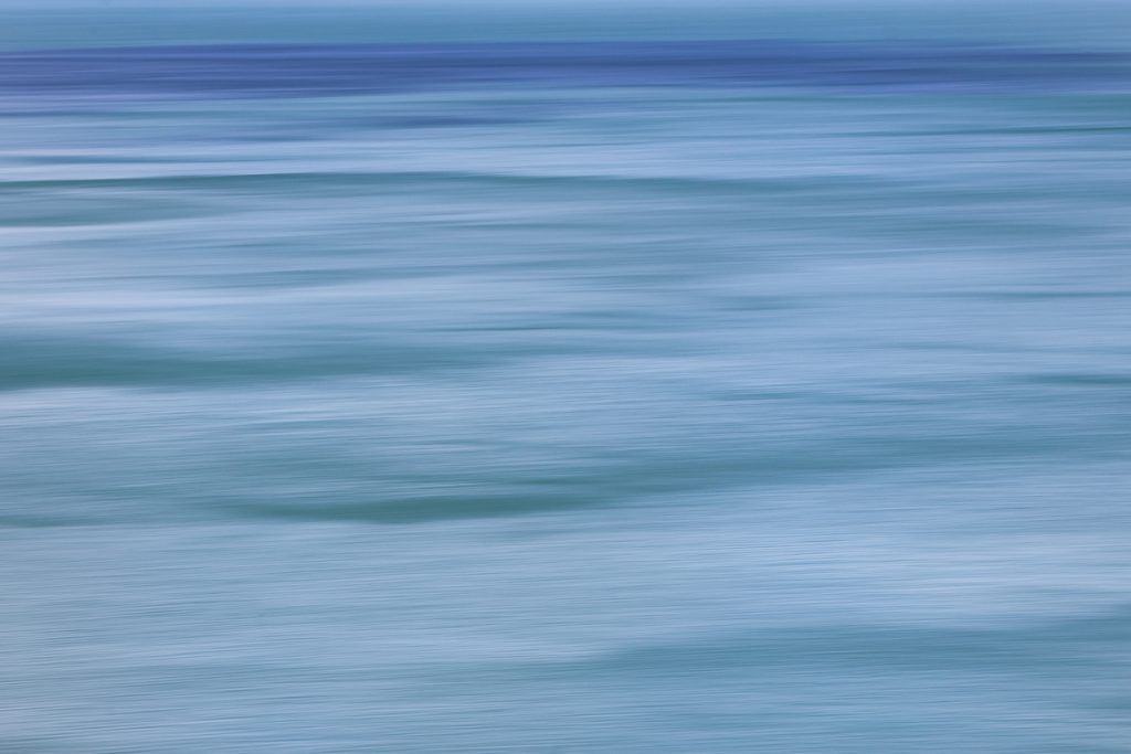 Several shades of blue horizontal lines that look like drawn - created using the ICM technique of panning horizontally