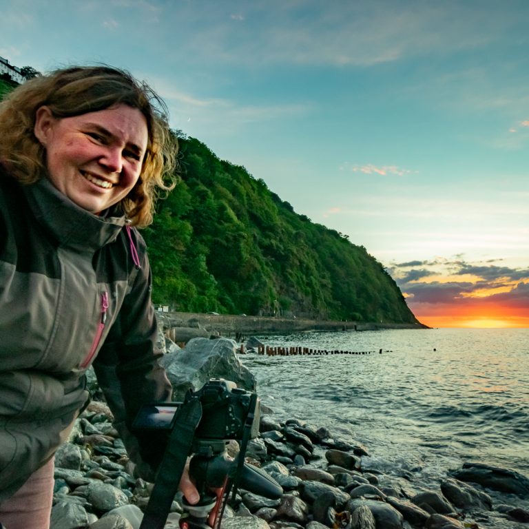 Kate Fish fotografierend bei Sonnenuntergang an der SüdWestküste Englandsküste