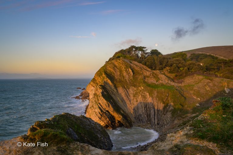 Goldene Stunde mit Blick nach Westen zur angeleuchteten Küste am Stairhole in England