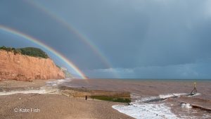 Eine Perspektive von vielen: vom Strand mit doppeltem Regenbogen über den Klippen von Sidmouth, UK
