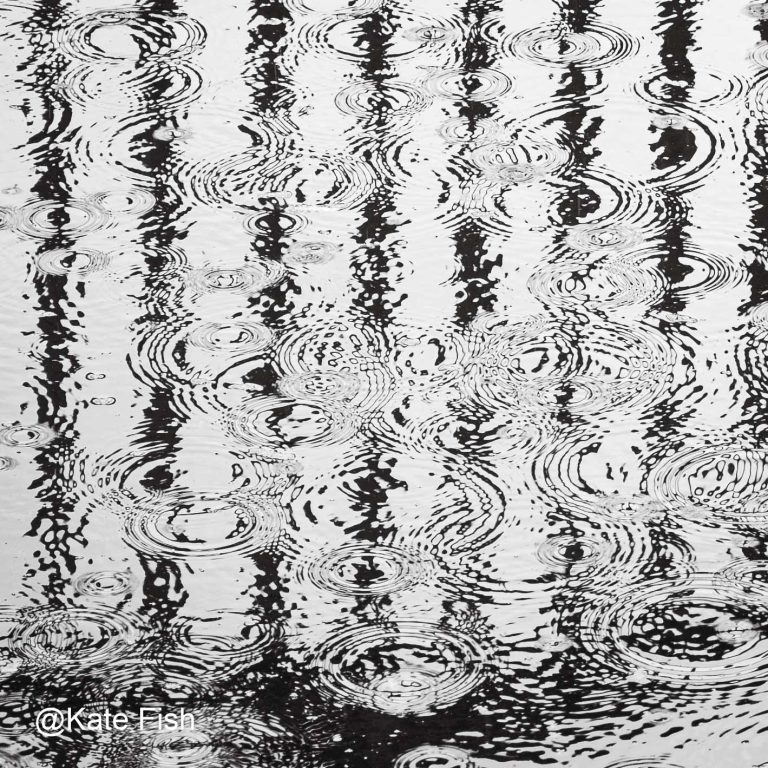 Spiegelung auf Wasser fotografieren. Hier ist der Fokus auf das Zusammenspiel von Linien gespiegelt im Wasser plus Regentropfen, die daraus Kreise erzeugen, gelegt. Detailaufnahme aus der Situation des vorigen Bildes.